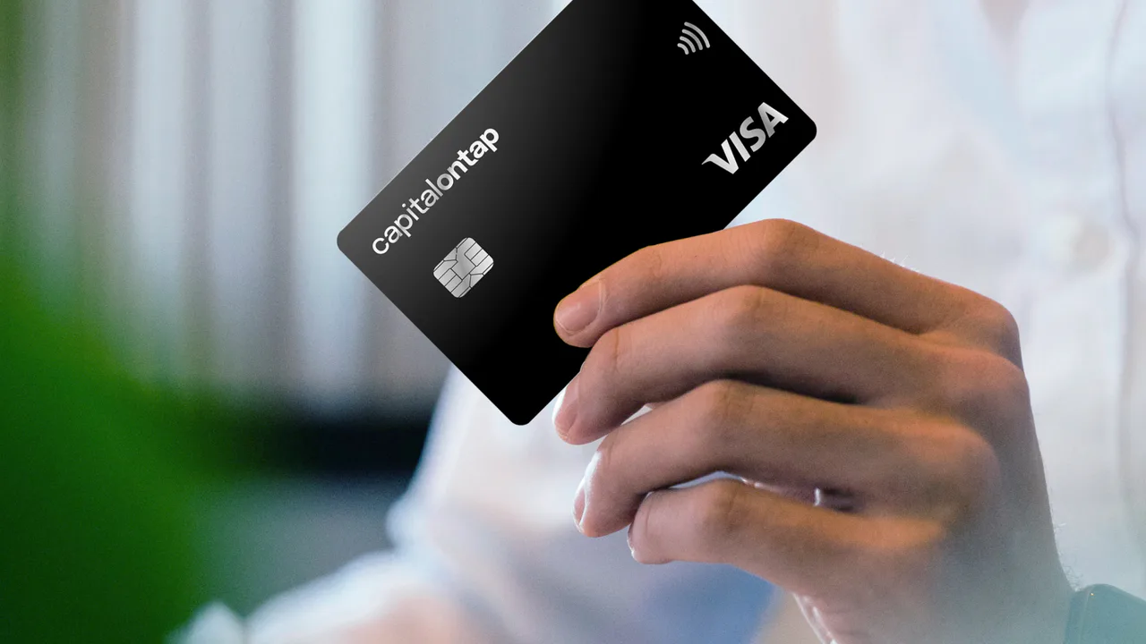 A person holding a Capital on Tap business payment card