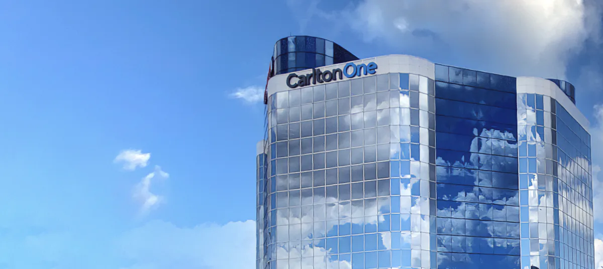 CarltonOne office building with the company name on its glass facade