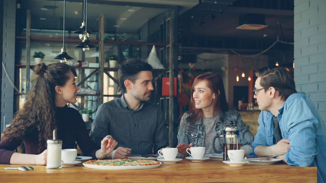 A group talking over pizza at a restaurant table