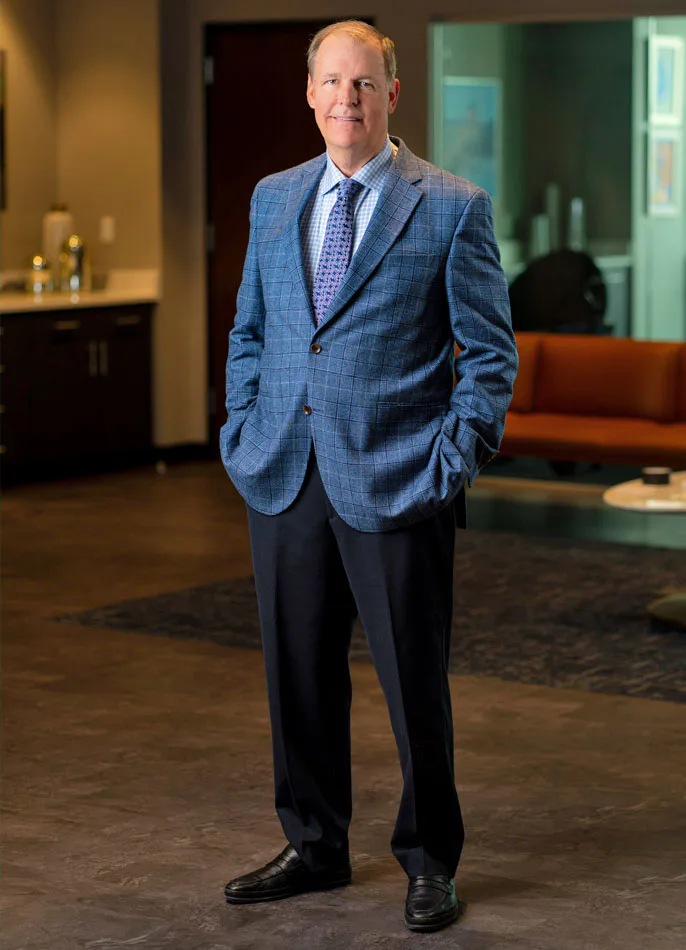 Official portrait of Michael J. Brown, chairman and CEO of Euronet Worldwide, standing in an office