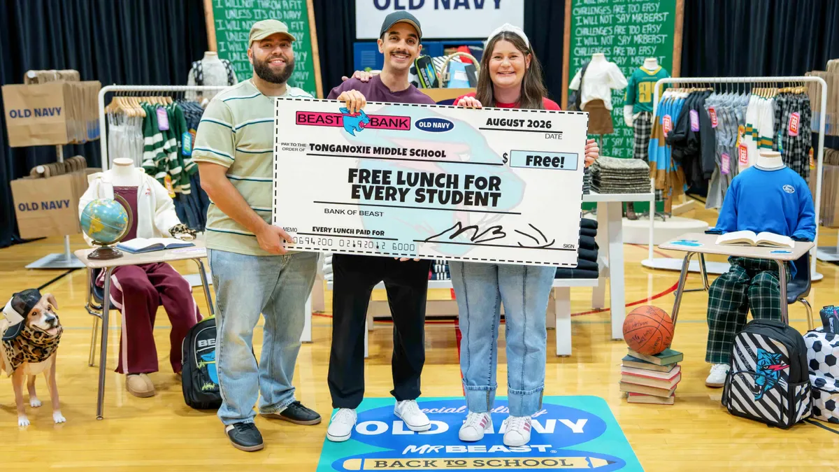 MrBeast and two campaign participants holding a school-lunch presentation check during the Old Navy back-to-school campaign