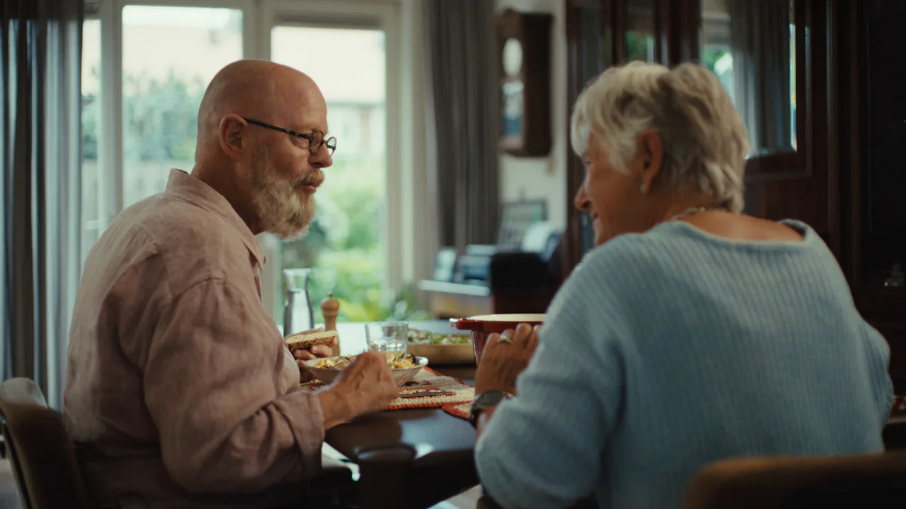 Two people sharing a meal in an official Schuif lekker aan campaign photograph.