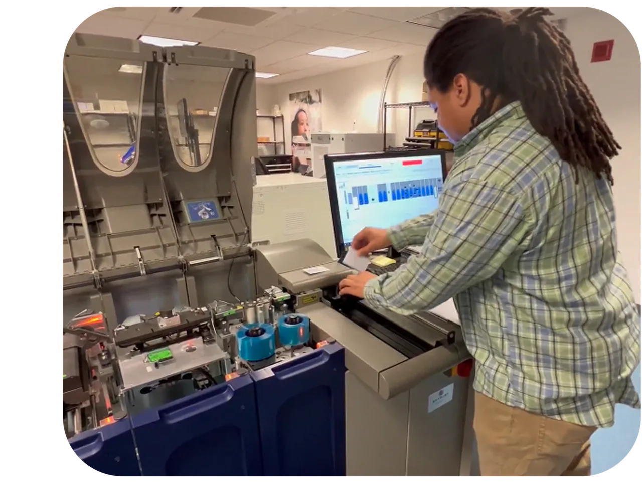 An operator working with card-production equipment in an official Wolfe merchant-services photograph